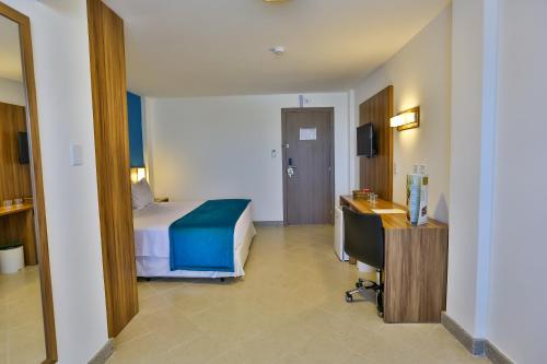 a hotel room with a bed and a desk at ARCUS Hotel By Atlântica in Aracaju