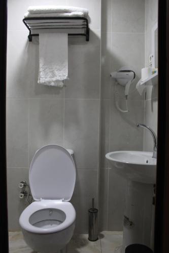 a bathroom with a white toilet and a sink at KONAK HOTEL 2 in Kars