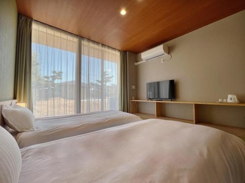 Habitación de hotel con 2 camas y ventana grande. en Kansai Airport Pine Villa, en Kansai International Airport