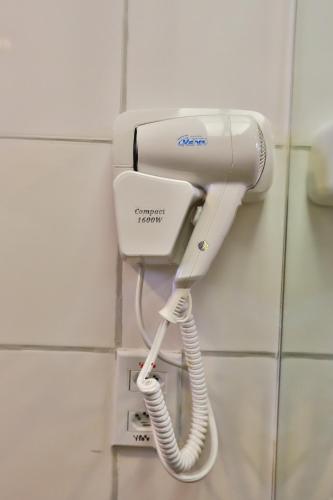 a phone is hanging on a wall in a bathroom at ARCUS Hotel By Atlântica in Aracaju
