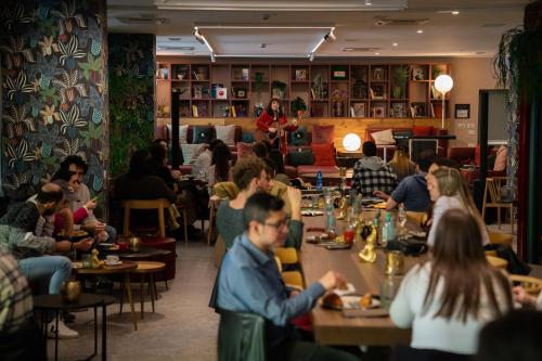 a group of people sitting at tables in a restaurant at 21 House of Stories Città Studi in Milan