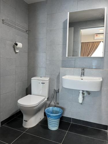 a bathroom with a toilet and a sink and a mirror at Splendours Condos@Jesselton Quay in Kota Kinabalu