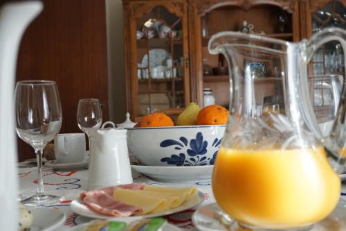 - une table avec une carafe de jus d'orange et de fromage dans l'établissement Jardim da Celeste, à Viana do Castelo