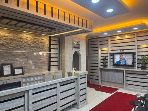 uma sala de estar com uma televisão e uma parede em KONAK HOTEL 2 em Kars