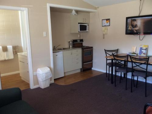 a room with a kitchen and a table and chairs at AAA Marlin Motel in Picton