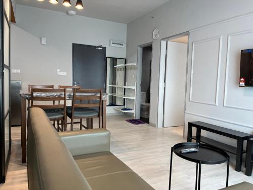 a living room with a couch and a table and chairs at Splendours Condos@Jesselton Quay in Kota Kinabalu