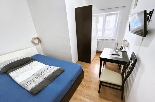 - une petite chambre avec un lit et un bureau dans l'établissement Penzion Zahrádka, à Lázně Bohdaneč