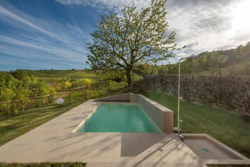 una piscina en el patio trasero de una casa en Borgo Roggeri - Country House nelle Langhe, en La Morra