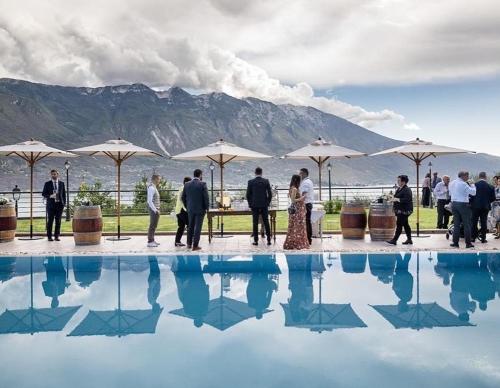 a group of people standing next to a swimming pool at Residence Dalco Suites & Apartments in Limone sul Garda