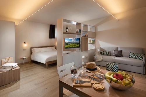 ein Wohnzimmer mit einem Sofa und einem Tisch mit einer Obstschale in der Unterkunft Borgo Roggeri - Country House nelle Langhe in La Morra