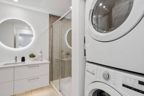 a white bathroom with a washing machine and a sink at Initial / Yogi+ Parking / Centre-Ville de Québec in Quebec City