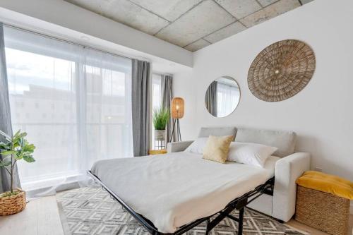 ein Schlafzimmer mit einem Bett und einem großen Fenster in der Unterkunft Initial / Yogi+ Parking / Centre-Ville de Québec in Québec
