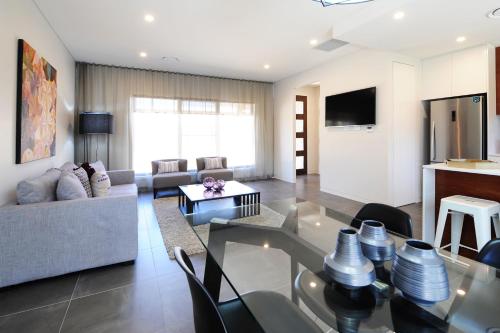 a living room with a glass table and a couch at Kirsten Accommodation Mudgee in Mudgee