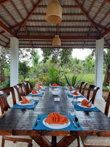 a long wooden table with blue plates and napkins at Villa Wodeyarmutt Tropical luxury living in Sringeri