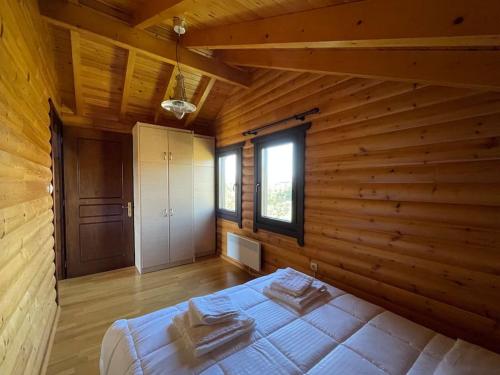 a bedroom with a bed in a wooden room at Chalet Klimatia - Όμορφη ξύλινη μεζονέτα με τζάκι in Klimatiá