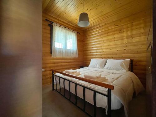 a bedroom with a bed in a wooden room at Chalet Klimatia - Όμορφη ξύλινη μεζονέτα με τζάκι in Klimatiá