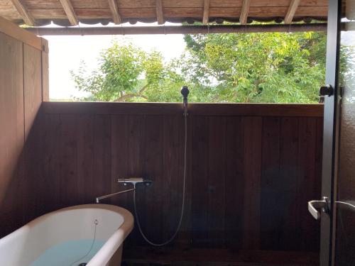 a bathroom with a bath tub and a window at 一汁一菜の宿　ちゃぶダイニング Ichiju Issai no Yado Chabu Dining Unforgettable Farmstay experience in Deep Kyoto in Ayabe
