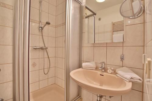 y baño con lavabo y ducha. en Haus Strandallee 24 Haus Strandallee 24 - Appartement Seemanns Meeresblick, en Scharbeutz