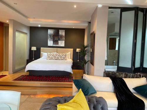 een slaapkamer met een groot bed en een bank bij Apartment on 8th in Johannesburg