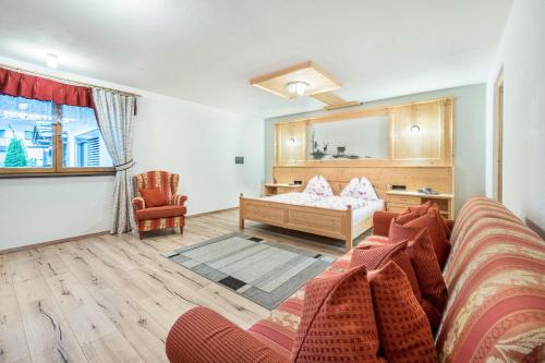 uma sala de estar com um sofá e uma cama em Alpen Living - 2 Stock em Cadipietra