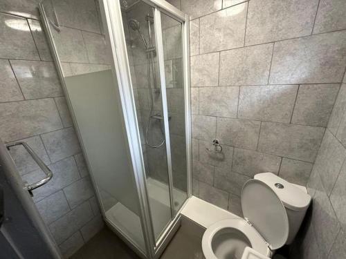 a bathroom with a shower stall and a toilet at BRAND NEW LARGE Studio Flat! in Hackbridge