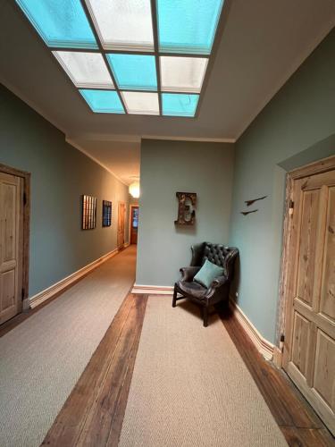 a living room with a skylight and a chair at Gutshaus Klein kussewitz in Klein Kussewitz