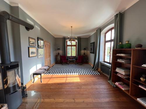 a living room with a wood floor and a fireplace at Gutshaus Klein kussewitz in Klein Kussewitz