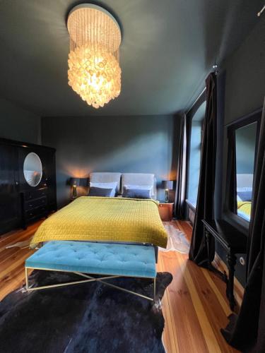 a bedroom with a yellow bed and a chandelier at Gutshaus Klein kussewitz in Klein Kussewitz