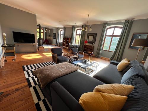 a living room with a couch and a flat screen tv at Gutshaus Klein kussewitz in Klein Kussewitz