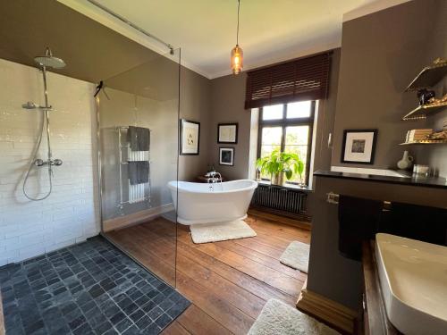 a bathroom with a tub and a shower and a sink at Gutshaus Klein kussewitz in Klein Kussewitz