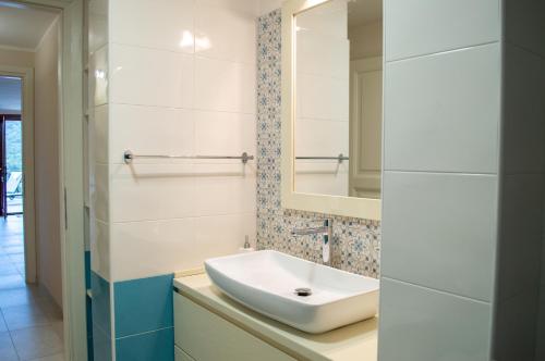 W łazience znajduje się umywalka i lustro. w obiekcie Villa Giada w mieście Torre delle Stelle