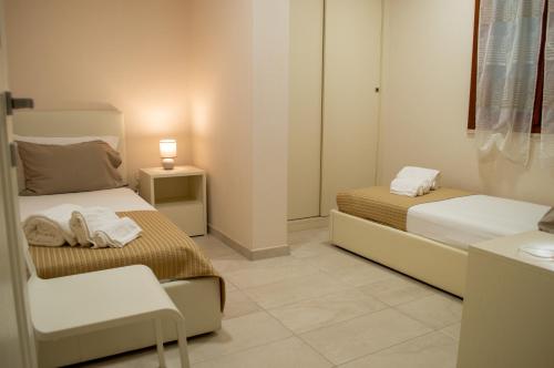 sypialnia z 2 łóżkami, stołem i lampką w obiekcie Villa Giada w mieście Torre delle Stelle