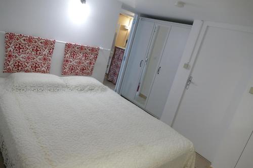 a bedroom with a white bed and a mirror at Appartement avec véranda donnant sur le jardin in Le Pontet