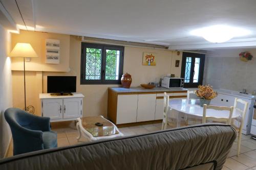 een keuken en een woonkamer met een bank en een tafel bij Appartement avec véranda donnant sur le jardin in Le Pontet