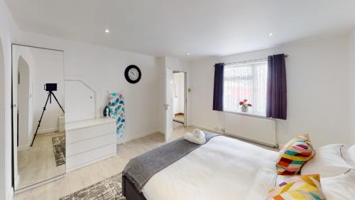 a white bedroom with a large bed and a window at Symons House in Chatham