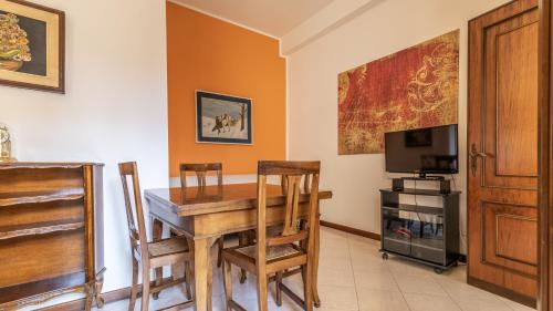 a dining room with a table and chairs and a television at Francesca Apartment in Sassuolo - Affitti Brevi Italia in Sassuolo