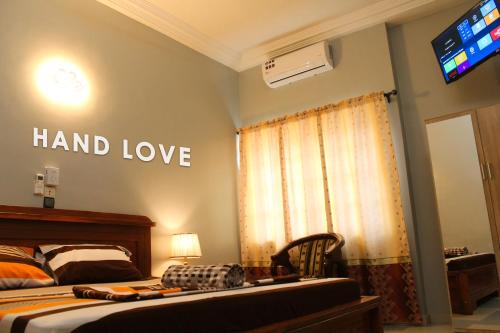 a bedroom with a bed with the words hand love on the wall at HAND LOVE in Cotonou