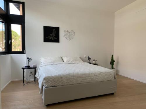 ein Schlafzimmer mit einem Bett und einer weißen Wand in der Unterkunft SKY in Lugano