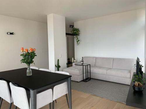 un soggiorno con tavolo nero e divano bianco di SKY a Lugano
