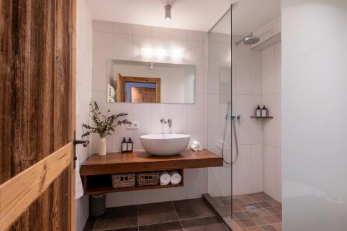 a bathroom with a sink and a glass shower at Kikombe Lodge in Sankt Anton am Arlberg