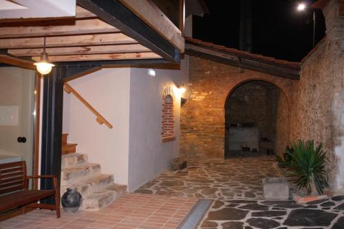 a large room with a stone wall and a fireplace at Vale das Maias - Casa de Campo in Laborins