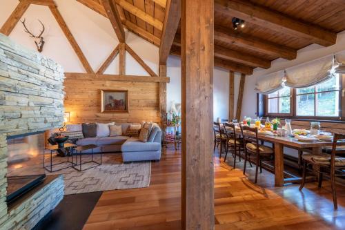 a dining room and living room with a stone fireplace at Kikombe Lodge in Sankt Anton am Arlberg