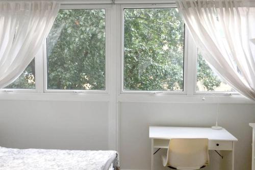ein weißes Schlafzimmer mit einem Schreibtisch und 2 Fenstern in der Unterkunft Fab 3-bed 3-bath Duplex Oxford Street, Regents Park, Fitzrovia W1 in London