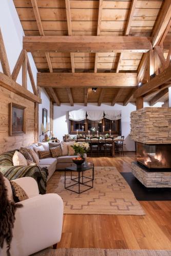 a living room with a stone fireplace in a house at Kikombe Lodge in Sankt Anton am Arlberg