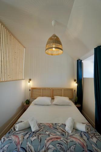 une chambre avec un grand lit et un lustre dans l'établissement Le perchoir *hyper centre * A 2 pas de la mer *, à Concarneau