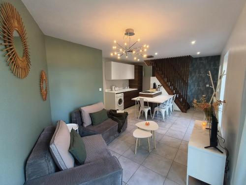 uma sala de estar com um sofá e uma mesa em Chez Emma et Louise - Maison individuelle avec stationnement em Mâcon