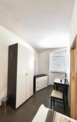 a bedroom with a black refrigerator and a desk at Penzion Zahrádka in Lázně Bohdaneč