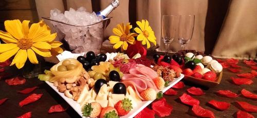 a table topped with two trays of food and flowers at Prana Guest House in Praia do Rosa