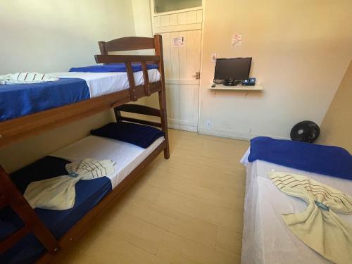 two bunk beds in a room with a television at Pousada Casa de Bragança II in Bragança Paulista