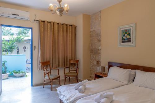a bedroom with a bed and two chairs and a window at Port Inn in Haifa